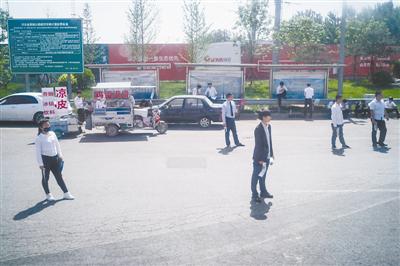 5月6日，河北固安，一些房产中介在高速路口等候购房者。