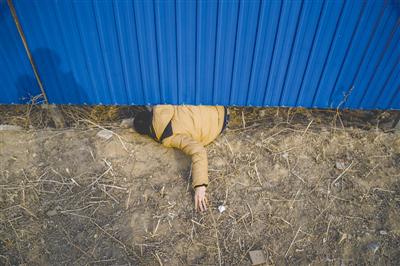 孙竹久屋子地点的小区被开辟商用彩钢板围了起来，已购房者想要出来看房只能从彩钢板下的漏洞间钻过。