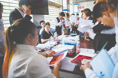 5月8日，河北燕郊的房管局年夜厅，房产中介正在为购房者操持相干手续。往年新的购房政策出台当前，燕郊住房买卖量有所降落。