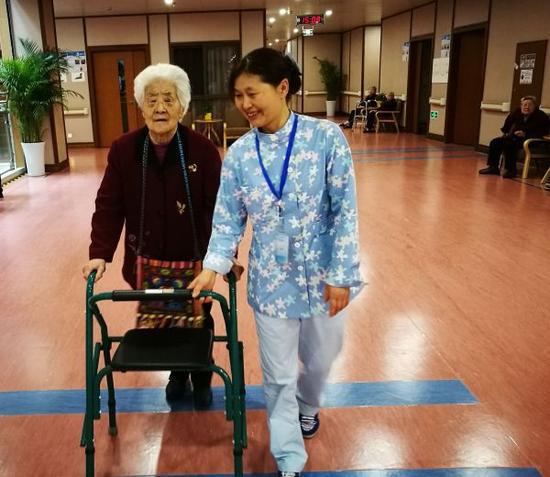 材料图片：照顾护士员正搀扶白叟停止行走痊愈练习。新华社记者董小红摄