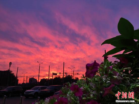  5月22日，北京，在阅历了一天的雨水后，北京的天空迎来了醉人的晚霞。图为白石桥地域晚霞。 中新网记者 李霈韵 摄