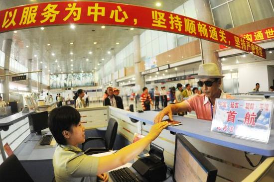 图说：材料图片：2012年7月12日，边防检讨员验放赴朝鲜旅客出境。新华社发