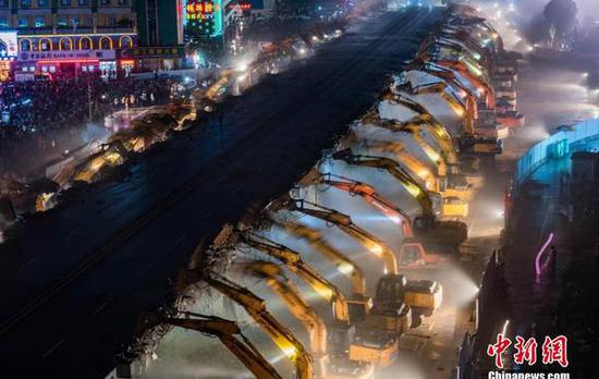 6月30日晚，江东北昌市龙王庙破交桥正式开端撤除。200余台发掘机收回隆隆的敲击声，退役了25年的南昌市龙王庙破交桥一点点被“啃食”，撤除现场颇为壮不雅。中新社发 王成梁 摄