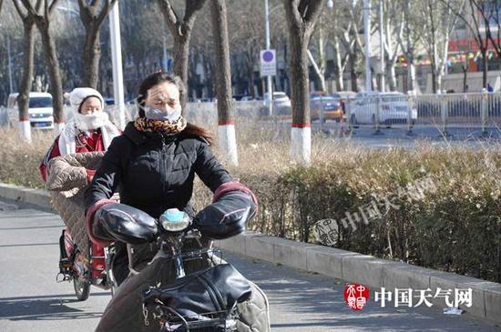 昨天，首府呼跟浩特气象严寒，市平易近武装出行。（图：袁梅）