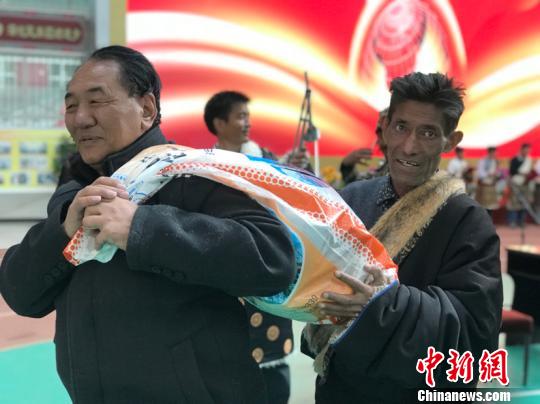 图为牧平易近将装有分成现金的麻袋背回家。　孙睿 摄