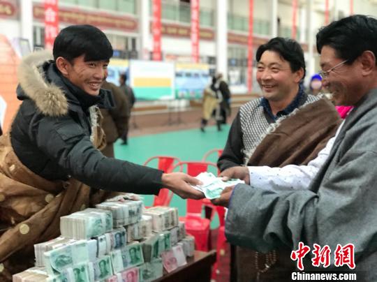 图为配合社担任人给牧平易近分成。　孙睿 摄